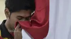 Pebulutangkis ganda putra Indonesia, Angga Pratama, mencium bendera saat seremoni pelepasan untuk Piala Sudirman di Kantor PBSI Cipayung, Jakarta, Sabtu (6/5/2017). (Bola.com/Vitalis Yogi Trisna)