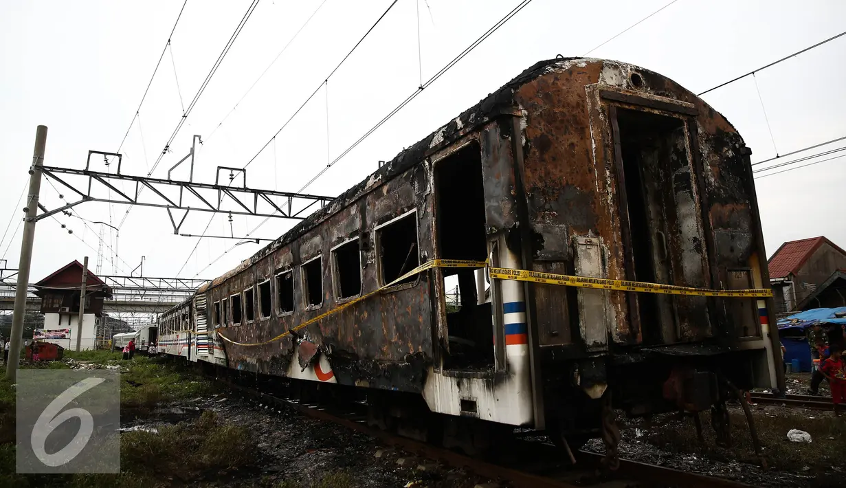 Garis polisi terpasang pada gerbong Kereta Kertajaya jurusan Surabaya-Jakarta yang terbakar di Stasiun Tanjung Priok, Jakarta, Kamis (25/8). Menhub Budi Karya meminta maaf atas peristiwa terbakarnya gerbong tersebut. (Liputan6.com/Faizal Fanani)