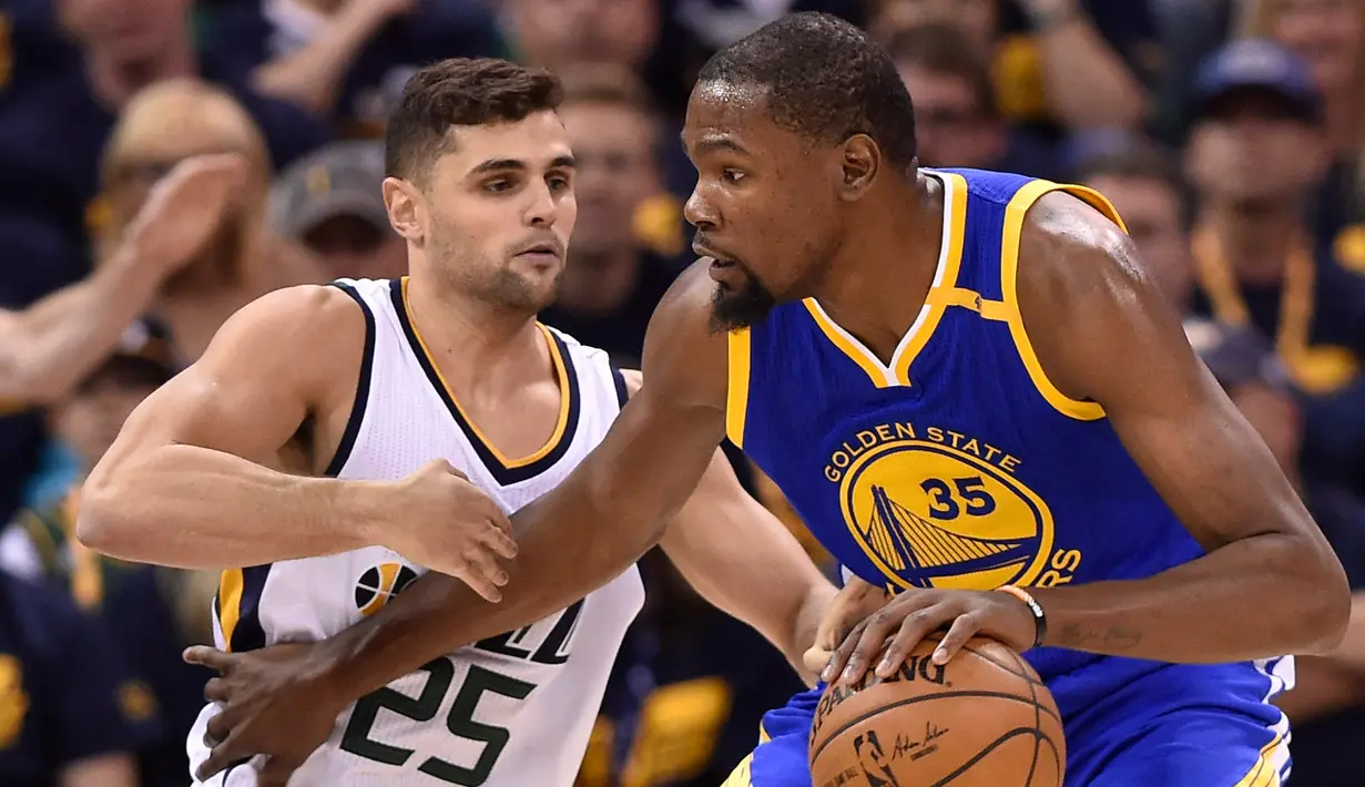 Pemain Utah Jazz, Raul Neto berusaha menghalangi Kevin Durant saat pertandingan Semifinal Wilayah Barat Playoffs NBA 2017 di Salt Lake City (5/6). Pertandingan ini dimenangkan Warriors dengan skor 102-91 atas Jazz. (Gene Sweeney Jr / Getty Images / AFP)