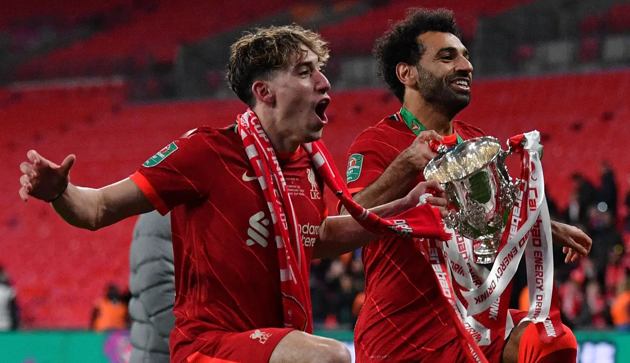 Mohamed Salah kembali berhasil membawa Liverpool merengkuh trofi juara, yakni Carabao Cup 2021/2022, usai mengalahkan Chelsea lewat babak adu penalti yang dramatis. Trofi tersebut menjadi gelar kelima Mo Salah selama hampir lima musimnya di Anfield. (AFP/Justin Tallis)