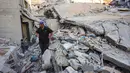 Seorang pria dan anak-anak melihat reruntuhan rumah yang hancur akibat serangan Israel di Khan Younis, Jalur Gaza selatan, pada Rabu 29 Oktober 2025. Untuk diketahui, Israel mulai melancarkan serangan udara sejak 28 Oktober 2025 setelah menuduh Hamas menyerang pasukan Israel di Gaza dan melanggar gencatan senjata. (BASHAR TALEB/AFP)