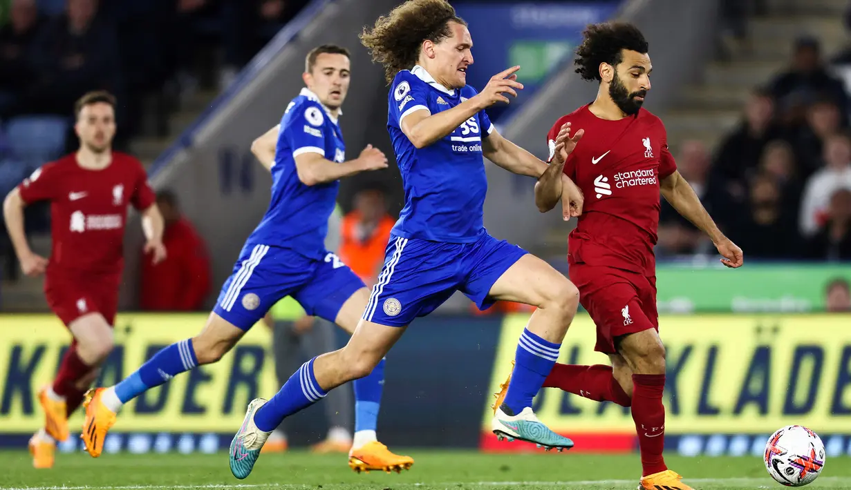 Striker Liverpool, Mohamed Salah (kanan) berusaha melewati bek Leicester City, Wout Faes pada laga Liga Inggris 2022/2023 di King Power Stadium, Licester (15/5/2023). Mohamed Salah yang kini menjalani musim ke-6 bersama Liverpool menjadi pemain terbaru alias keempat yang sukses mencetak hattrick assist di Liga Inggris pada musim 2022/2023. Momen itu terjadi di pekan ke-36 saat Liverpool menang 3-0 atas Leicester City. (AFP/Darren Staples)