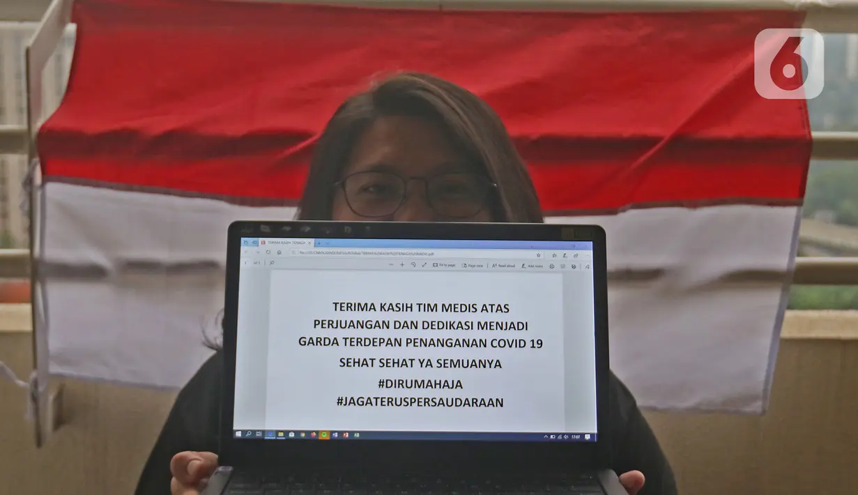 Seorang Mahasiswi menunjukkan tulisan dukungan di kawasan Bekasi, Jawa Barat, Senin (23/3/2020). Warga memberikan dukungan kepada tenaga medis yang berjuang dan berdedikasi dalam penanganan Covid-19. (Liputan6.com/Herman Zakharia)