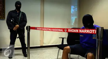 Tersangka AR yang menjadi kurir dihadirkan dalam rilis di kantor BNN, Jakarta, Selasa (27/10/2015). BNN mengamankan empat tersangka kasus narkoba dengan barang bukti 1000 butir pil ekstasi, dua diantaranya merupakan oknum TNI. (Liputan6.com/Yoppy Renato)