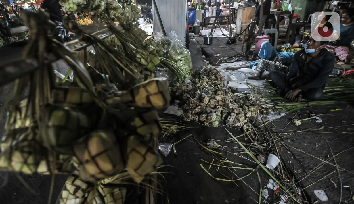 Pedagang bungkus atau tali ketupat saat menunggu pembeli di Pasar Klender, Jakarta Timur, Selasa (11/5/2021) malam. Menjelang Hari Raya Idul Fitri, Pasar Klender merupakan salah satu lokasi yang ramai dikunjungi warga untuk berburu ketupat, terutama saat malam hari. (merdeka.com/Iqbal S Nugroho)