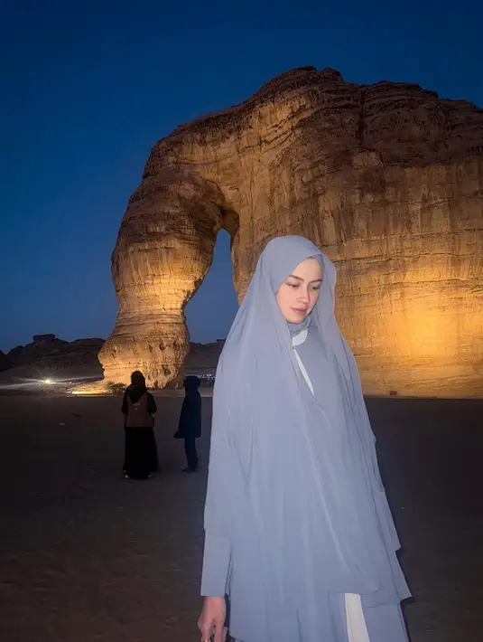 Berlatar belakang Elephant Rock yang ikonik di Al Ula, Kimberly tampak berdiri dengan ekspresi tenang dan penuh makna.  [@kimbrlyryder].