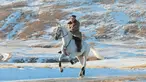 Pemimpin Korea Utara Kim Jong-un menunggangi kuda putih  saat salju yang turun di gunung Paektu (16/10/2019). Kim Jong-un tampil mengenakan kaca mata dengan mantel tebal berwarna coklat.  (Photo by STR/KCNA VIA KNS/AFP)