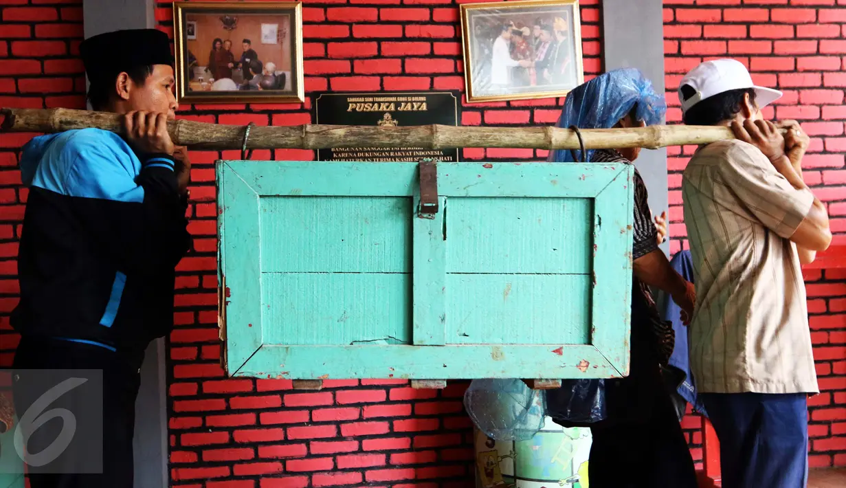 Sejumlah pemain Gong Si Bolong mengangkat peti yang berisikan gamelan serta gong besar untuk di bawa pentas dalam sebuah acara di kawasan Depok, 14 Januari 2017. (Liputan6.com/Helmi Afandi)