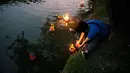 Seorang wanita Thailand melarung 'krathong' untuk merayakan festival Loy Krathong di sebuah danau di Bangkok, Kamis (22/11). Festival ini biasanya berlangsung pada akhir musim hujan, ketika bulan purnama menyala di langit pada November. (Jewel SAMAD/AFP)