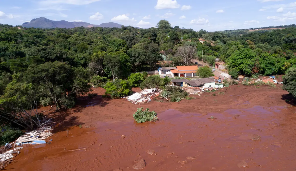 Banjir yang dipicu jebolnya bendungan menerjang rumah warga di Brumadinho, Brasil, Jumat (25/1). Beberapa orang yang terperangkap berhasil dievakuasi, dalam kondisi seluruh tubuh berselimut lumpur. (Bruno Correia/Nitro via AP)