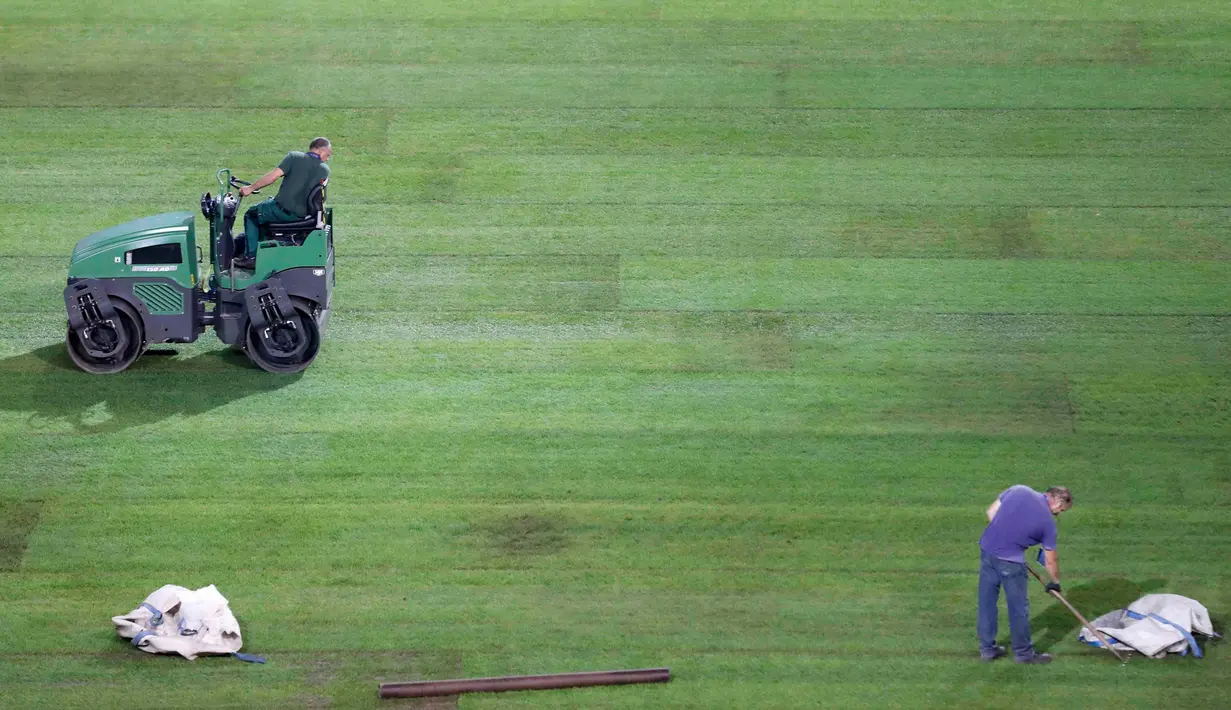 Pekerja melakukan pengilasan rumput di Stade Pierre Mauroy, Lille, Prancis, (23/6). Jelang laga 16 besar dan final Piala Euro 2016 pihak penyelenggara memanfaatkan waktu rehat dua hari untuk memperbaiki rumput lapangan bola. (REUTERS/Carl Recine)