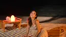 Saat makan malam di pinggir pantai, Gisella Anastasia tampil cantik dengan gaun strapline berwarna cokelat. Gaun sederhana ini memiliki motif warna warni di bagian dada. Warna gaunnya sendiri membuat Gisel menyatu dengan alam sekelilingnya.