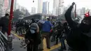 Pengunjuk rasa melemparkan batu ke arah wartawan yang meliput aksi protes yang berujung bentrok di Mongkok, Hong Kong, Selasa (9/2). Bentrokan dimulai ketika pemerintah daerah mencoba untuk menertibkan PKL yang beroperasi. (REUTERS / Bobby Yip)