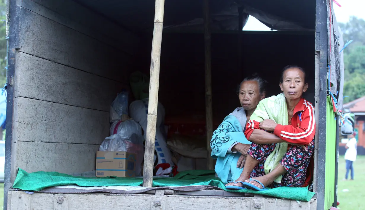 Warga pengungsi Gunung Agung beraktivitas di atas truk yang terparkir di Klungkung, Bali, Sabtu (23/9). Sebagian pengungsi memilih tinggal sementara dan menyimpan barang bawaan di atas truk karena merasa lebih nyaman. (AP Photo/Firdia Lisnawati)