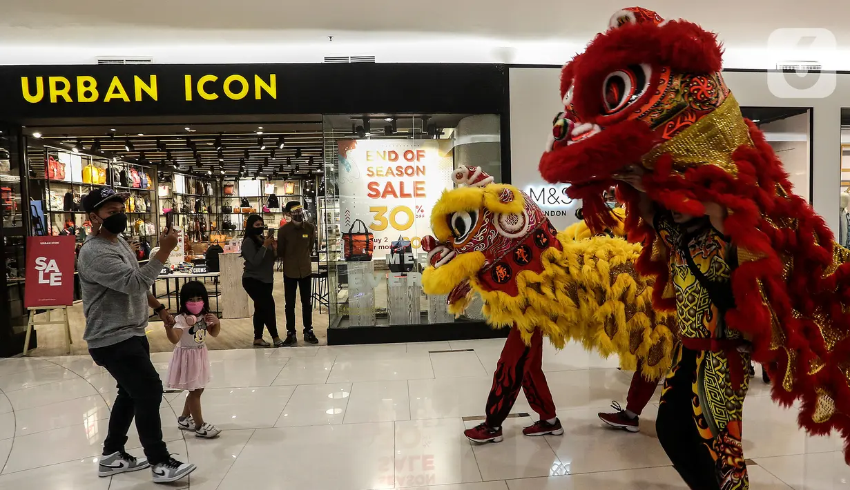Pengunjung mengabadikan Kelompok Barongsai yang beraksi untuk merayakan Tahun Baru Imlek 2572 di Senayan City mall, Jakarta, Jumat (12/2/2021). Selain menghibur, atraksi barongsai juga dipercaya masyarakat Tionghoa mampu mengusir roh-roh jahat yang mengganggu. (Liputan6.com/Johan Tallo)