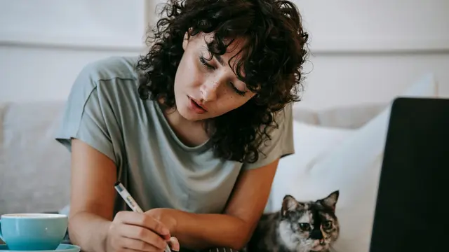 perempuan sedang menulis