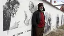 Nikolay berpose di depan mural bergambar dirinya bersama Paus Fransiskus di desa Staro Zhelezare, Bulgaria, Kamis (27/7). Penduduk setempat memenuhi dinding bagian luar rumah mereka dengan mural sejumlah tokoh dan musisi dunia (AP Photo/Valentina Petrova)