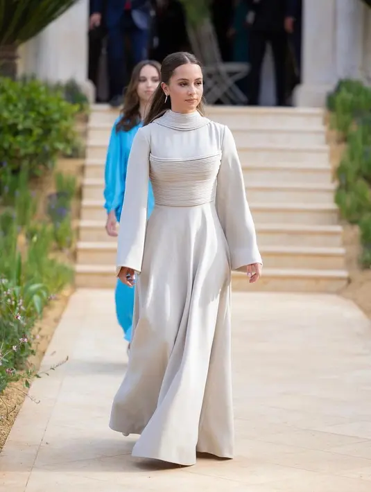 Putri Iman selaku adik putra mahkota Al Hussein tampil minimalis dengan gaun beraksen lipit pada bagian leher dada lansiran Stella McCartney. [Foto: IG/baitrania].