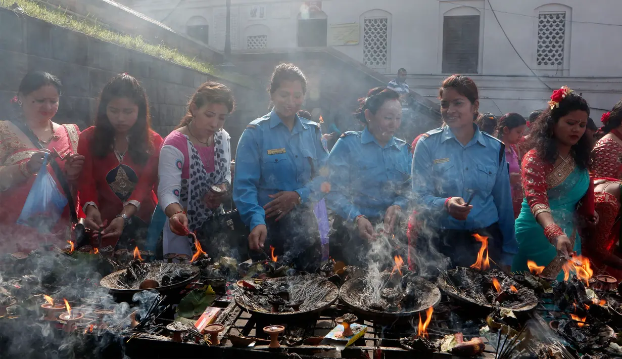 Sejumlah polwan Nepal turut menyalakan dupa di memasuki kuil Pashupatinath saat festival Teej di Kathmandu, Kamis (24/8). Dalam perayaan selama tiga hari itu, para perempuan menggelar berbagai macam pesta ritual sambil berpuasa. (Niranjan Shrestha/AP)