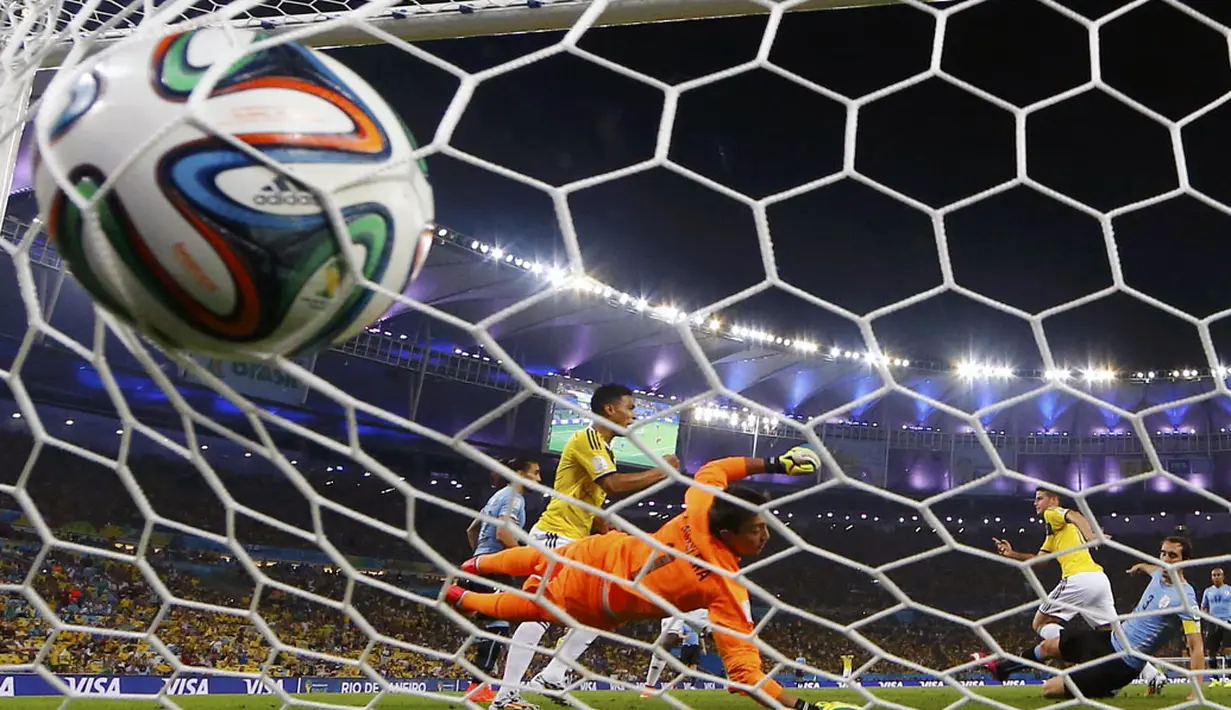 Gol kedua pemain tengah Kolombia, James Rodriguez, ke gawang Uruguay yang dikawal Fernando Muslera di laga 16 besar Piala Dunia 2014 di Stadion Maracana, Rio de Janeiro, (29/6/2014). (REUTERS/Michael Dalder) 