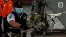 Petugas membawa serpihan pesawat Sriwijaya Air SJ-182 yang jatuh di perairan Pulau Seribu, di Dermaga JICT, Jakarta, Selasa (12/1/2021). Pada hari keempat evakuasi ini petugas gabungan menyerahkan kantong-kantong berisikan, bagian tubuh, serpihan pesawat. (Liputan6.com/Johan Tallo)