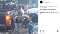 Seorang bule pria dengan sengaja membuka celan dan mendekatkan bagian bokongnya ke knalpot mobil. (Instagram)