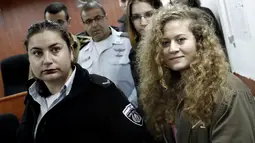Gadis remaja asal Palestina, Ahed Tamimi terseyum saat berada di pengadilan militer Israel di penjara Ofer, Israel (13/2). Jika terbukti bersalah, Ahed Tamimi akan terancam menghadapi hukuman penjara yang panjang. (AFP/Thomas Coex)