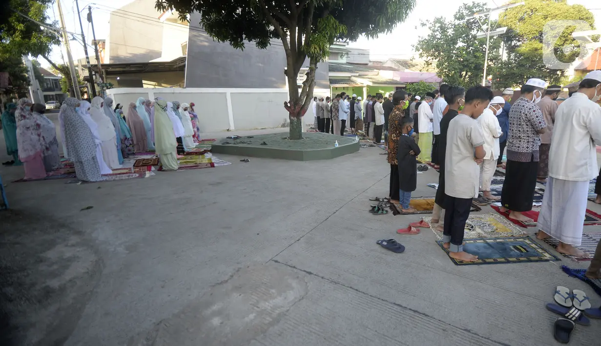 Jemaah melaksanakan salat Idul Fitri di pelataran Masjid Al Kahfi Griya Pamulang 2, Parakan, Pamulang, Tangerang Selatan, Banten, Minggu (24/5/2020). Di tengah pandemi virus corona COVID-19, jemaah yang hadir mengenakan masker untuk mencegah penularan. (merdeka.com/Dwi Narwoko)