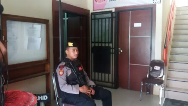 Polisi bersenjata berjaga saat penggeledahan berlangsung di Kantor Dinas Lingkungan Hidup Makassar (Liputan6.com/ Eka Hakim)