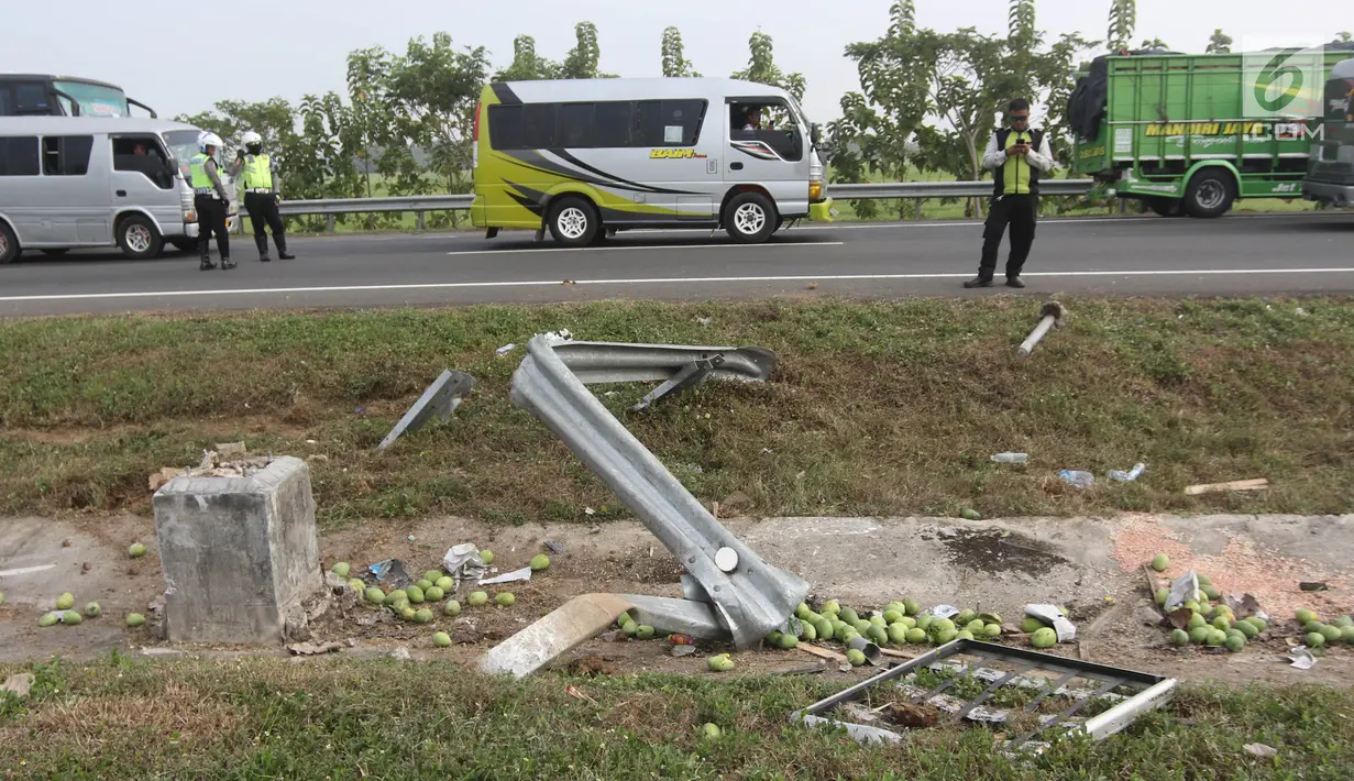 Pembatas jalan tol dan buah mangga rusak dan berceceran akibat kecelakaan mobil Grand max yang terjadi di KM 152 Tol Cipali, Jawa Barat, Minggu (10/6).Kecelakaan terjadi karena mobil oleng dan menabrak pembatas jalan tol. (Liputan6.com/Arya Manggala)