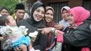 Calon Wakil Gubernur DKI Sylviana Murni mengendong bayi warga saat gerilya ke Jalan Famili, Jagakarsa, Jakarta Selatan, Kamis (5/1). Selain meminta dukungan, Sylvi juga memaparkan visi misinya bila terpilih nanti. (Liputan6.com/Yoppy Renato)