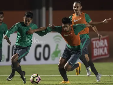 Pemain Timnas Indonesia, Febri Hariyadi, berusaha melewati Fachrudin Aryanto saat latihan di Stadion Maguwoharjo, Sleman, Selasa (11/6/2017). Latihan ini persiapan jelang ujicoba melawan Puerto Rico. (Bola.com/Vitalis Yogi Trisna)