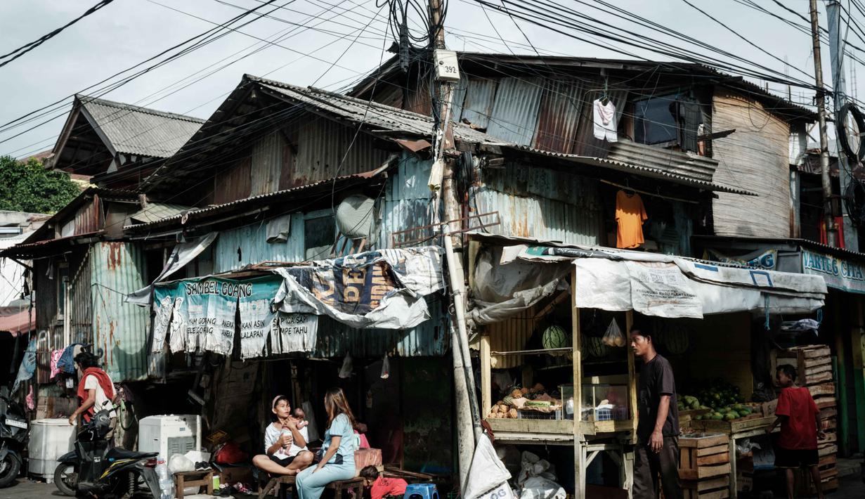 Selain itu, program Kredit Usaha Rakyat (KUR) juga menjadi instrumen penting dalam menopang pertumbuhan. Tampak dalam foto, seorang ibu memeluk putrinya yang berusia dua minggu di depan rumahnya di Jakarta pada Sabtu 8 November 2025. (YASUYOSHI CHIBA/AFP)