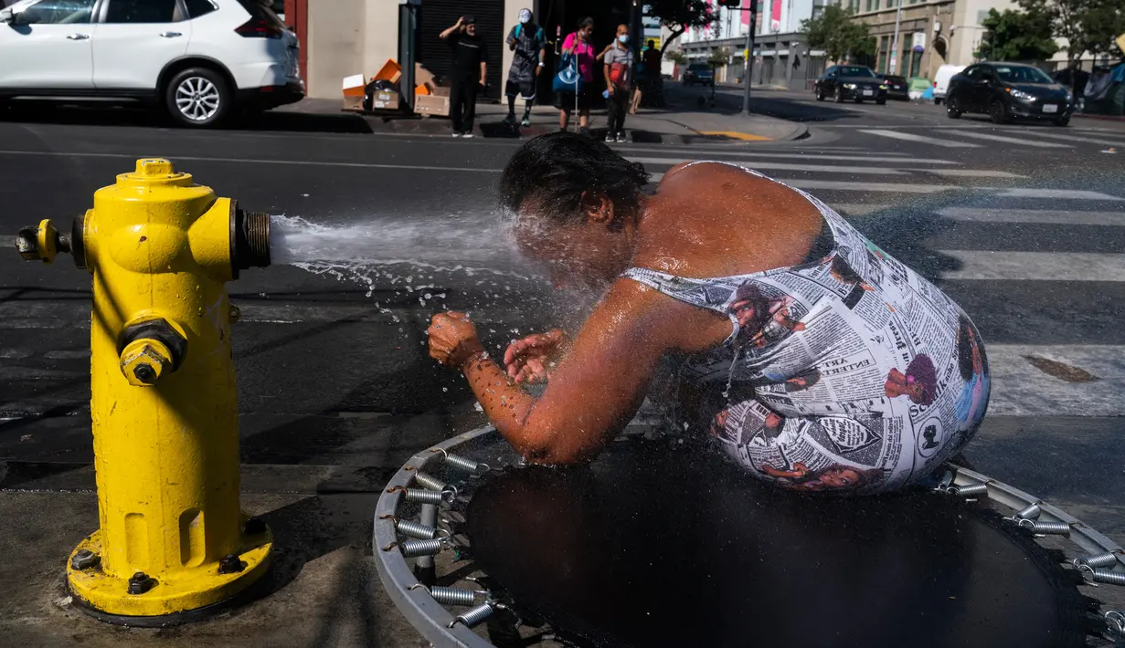 Stephanie Williams, mendinginkan diri dengan air dari hidran di daerah Skid Row di Los Angeles, Rabu (31/8/2022). Peringatan panas berlebihan meluas ke seluruh California Selatan dan utara ke Central Valley pada Rabu, diperkirakan akan menyebar ke California Utara di akhir minggu. (AP Photo/Jae C.Hong)