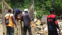 Warga bersama petugas BPBD dan relawan membongkar rumah rusak akibat longsor di Desa Kebutuhjurang. (Foto: Liputan6.com/Dinkominfo PBG/Muhamad Ridlo)