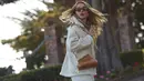 Rita Ora memadukan tampilannya dengan tas FENDI First dan busana bernuansa all white, mulai dari outerwear hingga celana panjang yang dikenakannya. Foto: Document/FENDI.