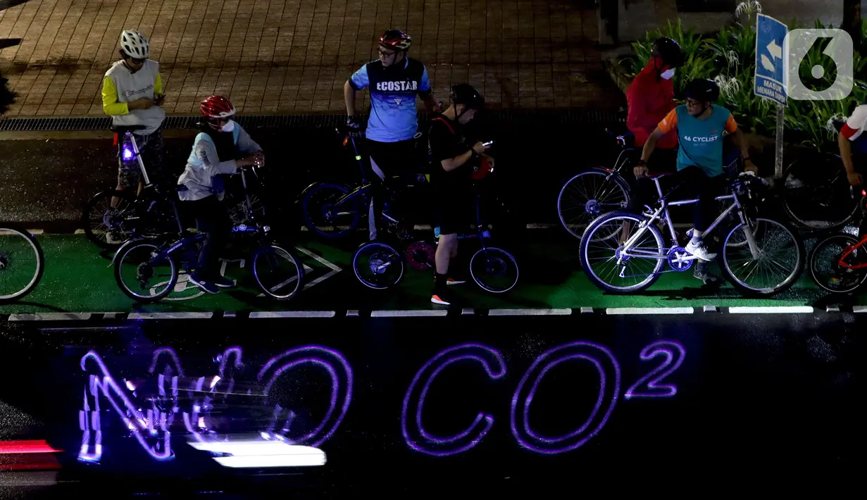 Pegiat bersepeda dan aktivis pecinta lingkungan saat aksi gowes Kelap Kelip Jakarta Night Ride #NOP26 di Kawasan Dukuh Atas, Jalan Jenderal Sudirman, Jakarta, Jumat (26/11/2021). Aksi bertujuan untuk mendorong penggunaan sepeda sebagai solusi transportasi nol emisi. (Liputan6.com/Helmi Fithriansyah)