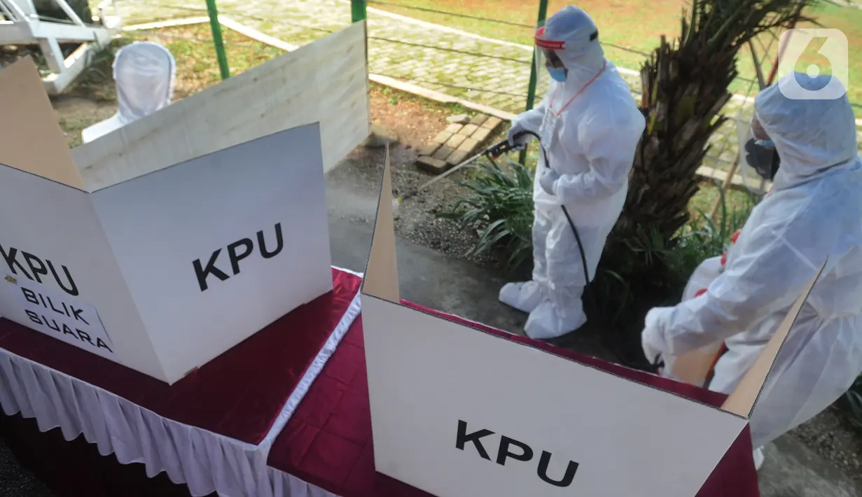 Petugas dengan memakai baju hazmat menyemprotkan disinfektan di area TPS 46, Paku Jaya, Serpong Utara, Rabu (9/12/2020). Para petugas KPPS di TPS 46 ini mengunakan seragam APD saat Pilkada Tangerang Selatan 2020 untuk mengantisipasi penyebaran COVID-19. (merdeka.com/Arie Basuki)