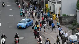 Pekerja berjalan kaki saat pulang kantor di Jalan Sudirman menuju Bendungan Hilir, Jakarta, Rabu, (22/4/2015). Tak adanya bus yang melintas karena adanya pengalihan arus untuk KAA membuat mereka terpaksa jalan kaki. (Liputan6.com/Johan Tallo)