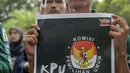 Seorang mahasiswa menunjukkan poster saat menggelar aksi di Gedung KPU, Jakarta, Selasa (23/4). Dalam Aksinya mereka mendesak KPU RI segera menyelesaikan permasalahan pemilu dan responsif dalam menindak  aduan masyarakat demi tercapai pemilu yang bersih dan adil. (Liputan6.com/Faizal Fanani)