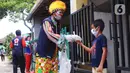 Komunitas Badut Tangerang  Raya (Batara) membagikan paket masker dan sabun cuci tangan gratis kepada warga di Larangan Selatan, Tangerang, Kamis (16/4/2020). PMI Kota Tangerang bersama Batara membagikan masker dan sabun cuci tangan untuk mencegah penyebaran COVID-19. (Liputan6.com/Angga Yuniar)