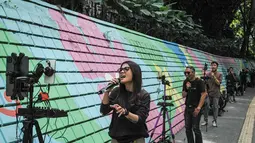Beberapa platform media sosial seperti TikTok, YouTube, dan Instagram bertransformasi menjadi panggung virtual di mana penyanyi dapat langsung menjangkau jutaan pendengar tanpa melalui agensi atau pihak lain. Tampak dalam foto, para penyanyi dalam jaringan (daring/online) menggunakan dinding berwarna-warni sebagai latar belakang tampil untuk menarik penonton agar memberikan donasi digital selama siaran langsung mereka di situs media sosial, Bandung, Jawa Barat, pada Jumat 8 Mei 2026. (Timur Matahari/AFP)