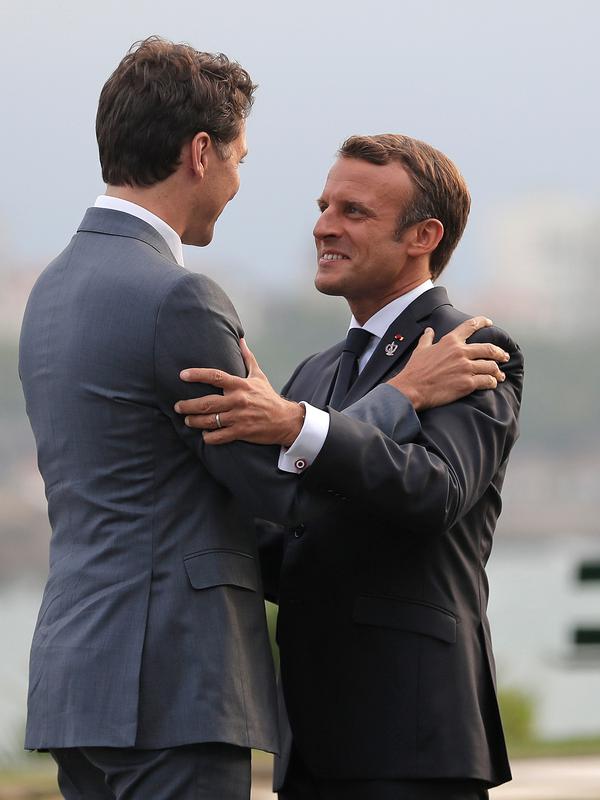 Presiden Prancis Emmanuel Macron (kanan) memeluk Perdana Menteri Kanada Justin Trudeau saat menyambut kedatangannya di KTT G7, Biarritz, Prancis, Sabtu (24/8/2019). Negara-negara G7 mewakili lebih dari 64 persen kekayaan bersih global. (AP Photo/Markus Schreiber)