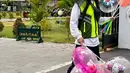 Dalam potret yang dibagikan, selain tangan kanan dan kirinya memegang balon, Baim juga dandan ala kadarnya. Memakai sepatu, rompi, dengan rambut panjang. Baim juga mengenakan topi hitam dan masker putih. [Instagram/baimwong]