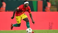 Gelandang Guinea, Aguibou Camara berlari dengan bola dalam pertandingan melawan Senegal di Piala Afrika 2024 di Stade Charles Konan Banny di Yamoussoukro pada 23 Januari 2024. (Issouf SANOGO / AFP)
