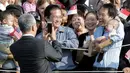 PM Singapura, Lee Hsien Loong mengambil gambar dengan ponselnya ketika menyapa warga pada upacara penyambutan kedatangannya di Gedung Putih, Washington, Selasa (2/8). (REUTERS/Joshua Roberts)