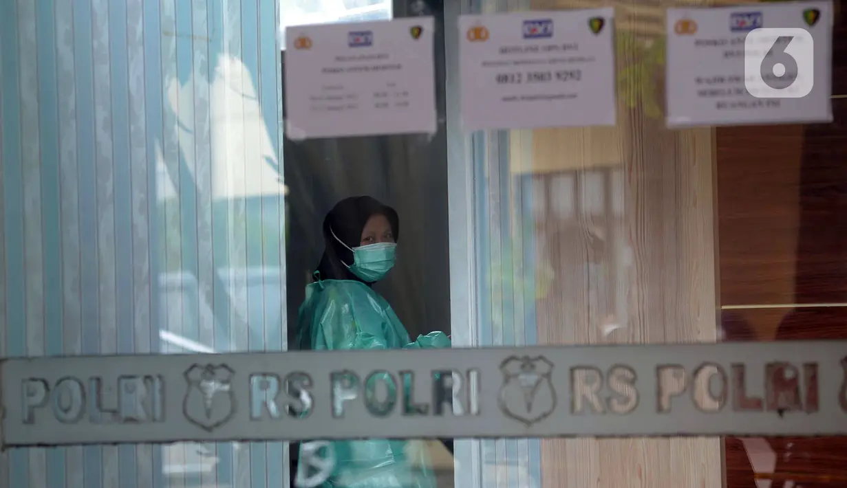 Seorang wanita yang mengenakan masker terliat di Posko Ante Mortem-DVI RS Polri Jakarta, Selasa (12/1/2021). Hingga saat ini, tim DVI masih mengumpulkan sampel DNA penumpang pesawat Sriwijaya Air SJ 182 yang jatuh di perairan Kepualauan Seribu. (merdeka.com/Imam Buhori)