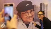 Pengunjung foto di depan poster Presiden ke-3 RI, Bacharuddin Jusuf Habibie saat pembukaan Habibie Festival di Museum Nasional, Jakarta, Kamis (11/8). Acara diadakan dalam rangka merayakan ulang tahun B.J Habibie ke-80. (Liputan6.com/Immanuel Antonius)