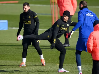 Penyerang PSG Kylian Mbappe (kanan) menendang bola melewati Lionel Messi selama sesi latihan di tempat latihan klub di Saint-Germain-en-Laye, sebelah barat Paris, Jumat (3/3/2023). PSG akan menjamu Nantes di Parc des Princes pada pekan ke-26 Ligue 1 2022/2023, Minggu, 5 Maret 2023 dini hari WIB. (Photo by FRANCK FIFE / AFP)