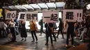 Demonstran menunjukkan pesan tuntutan mereka saat ribuan pegawai negeri sipil (PNS) mengikuti unjuk rasa menolak RUU Ekstradisi di Hong Kong, Jumat (2/8/2019). Banyak PNS yang memakai topeng hitam untuk menyembunyikan identitas mereka. (LAUREL CHOR/AFP)